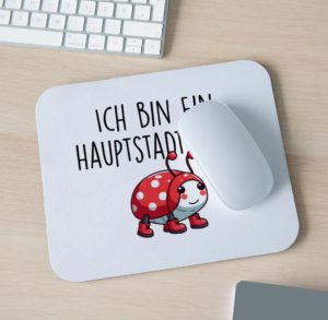 Abbildung eines Maus-Pads mit Maus und Teilen einer Tastatur sowie dem Logo „Ich bin ein Hauptstadtkäfer“ und dem Käferbild mit Stiefeln.